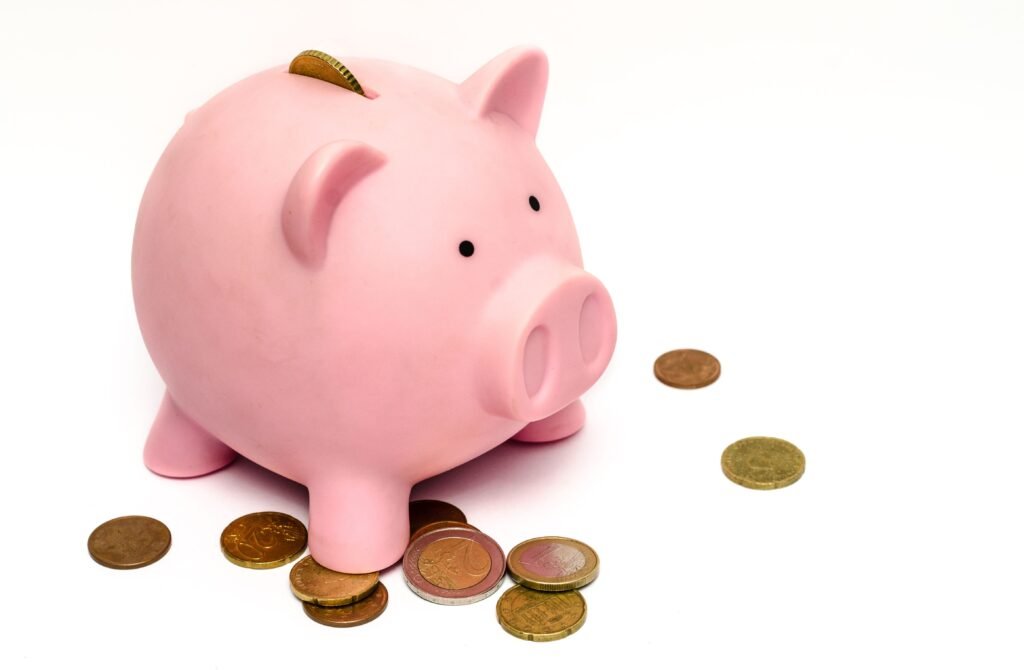 Piggy bank surrounded by coins, representing saving up to buy a home